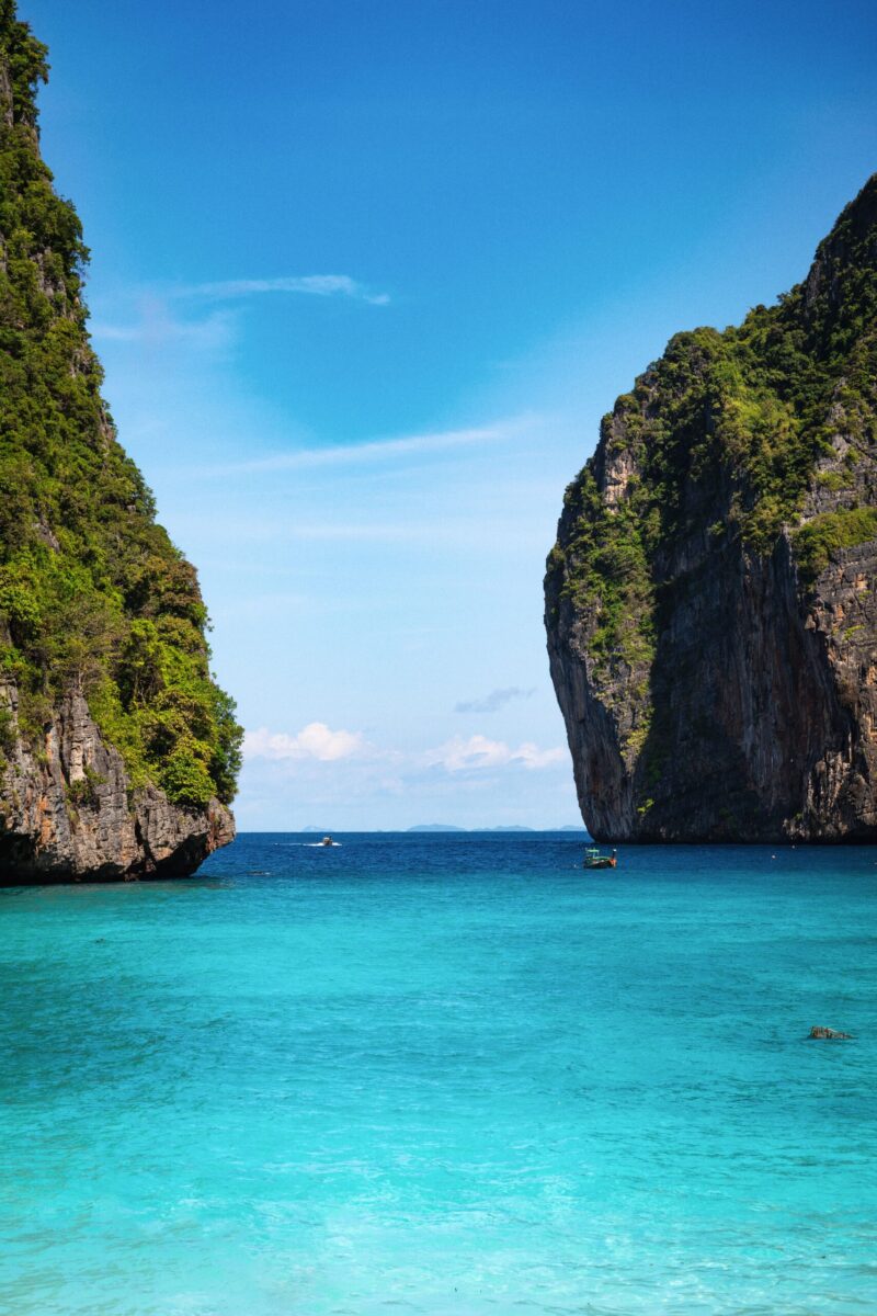 Breathtaking view of turquoise waters and towering limestone cliffs under a clear sky in Krabi, Thailand.